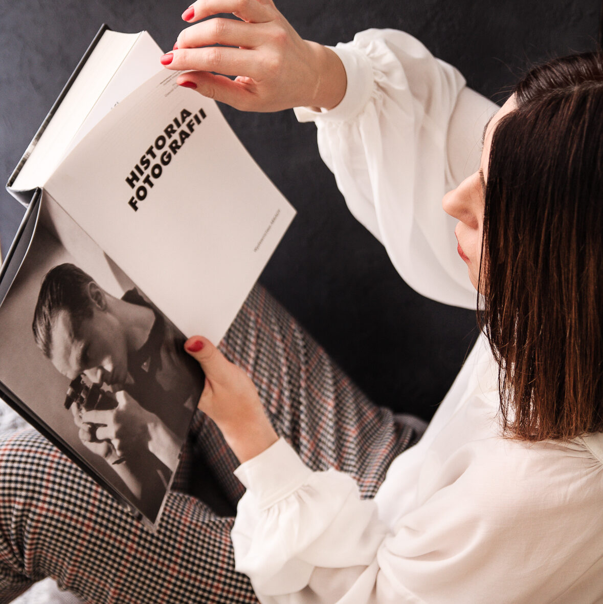 kobieta czytająca książkę o historii fotografii