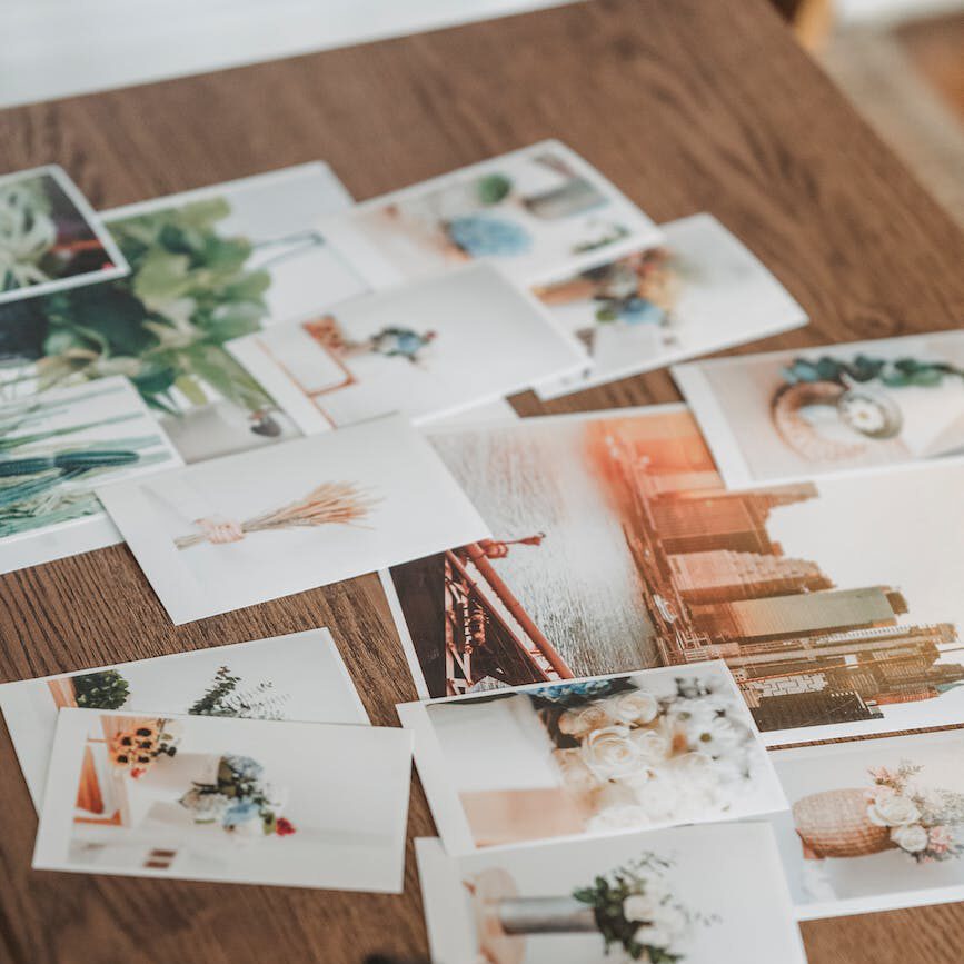 printed photos scattered on wooden table