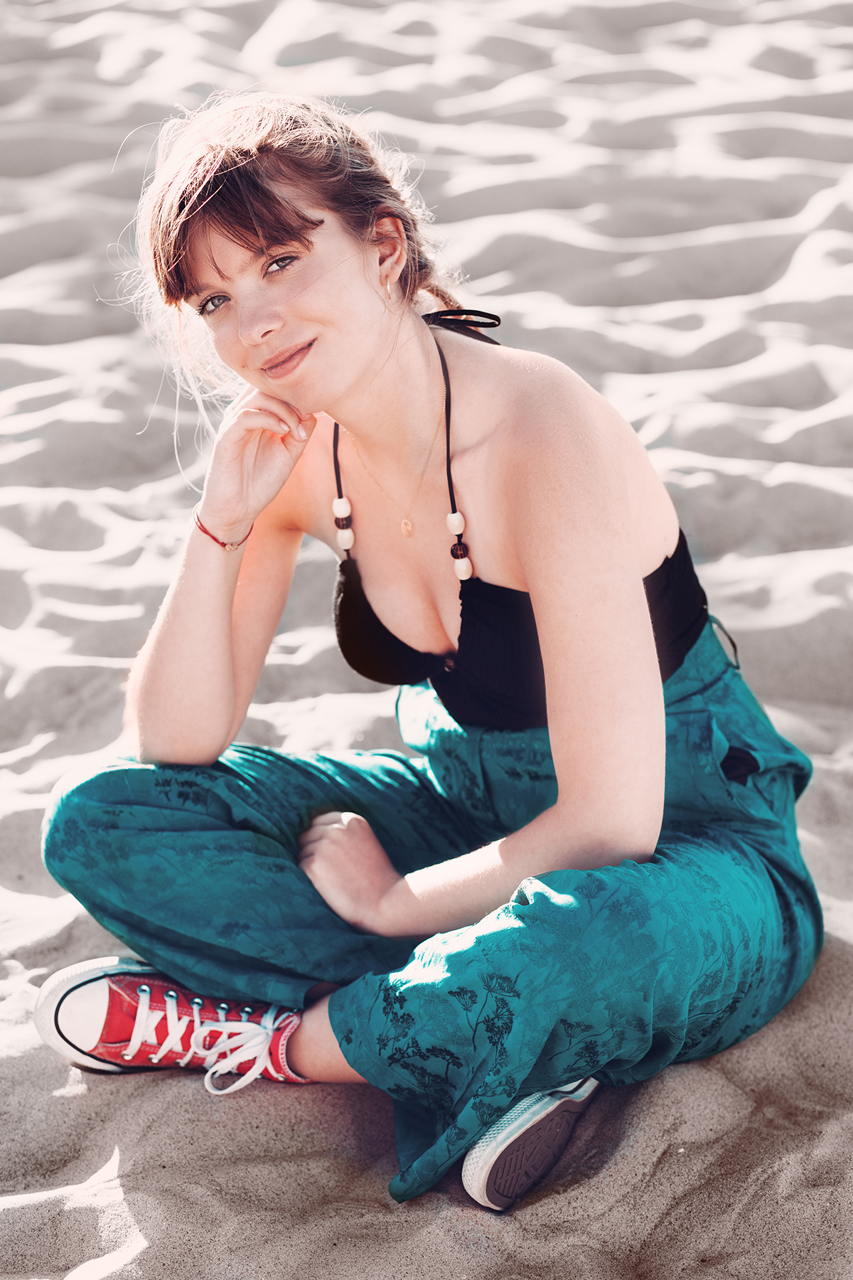 dziewczyna oparta na kolanie siedzi na plaży