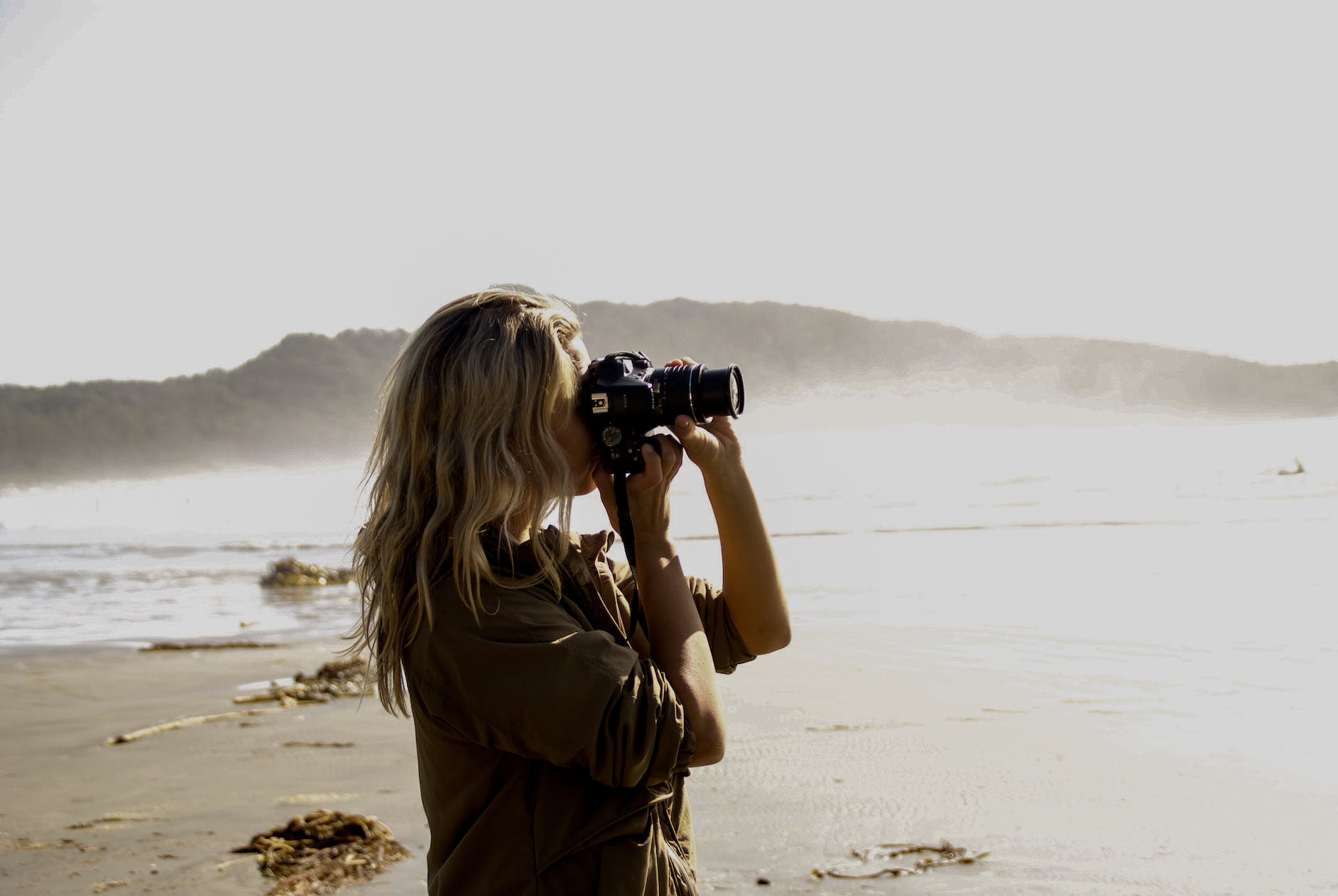 woman holding a black dslr camera and taking pictures
